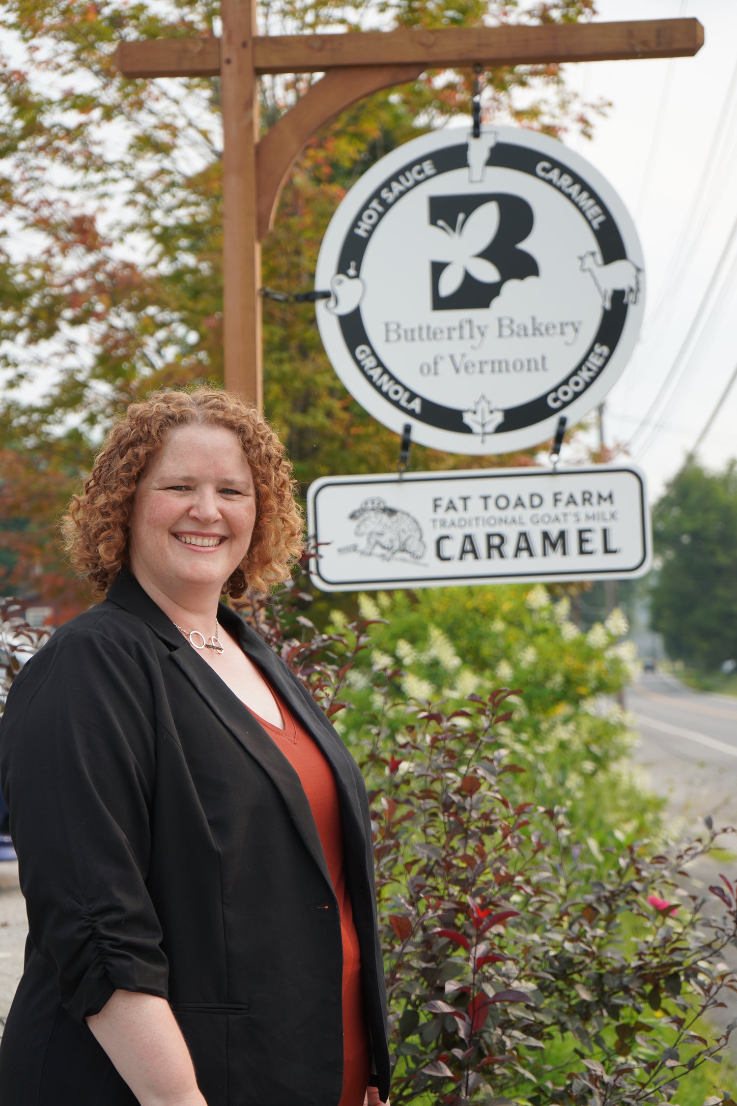 Claire Georges standing in front of her bakery's signs