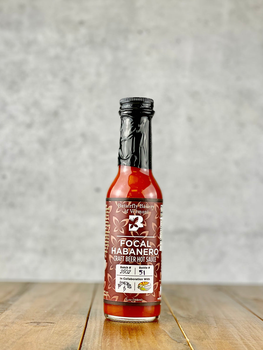 Bottle of Focal Habanero hot sauce from Butterfly Bakery of Vermont on a wood table
