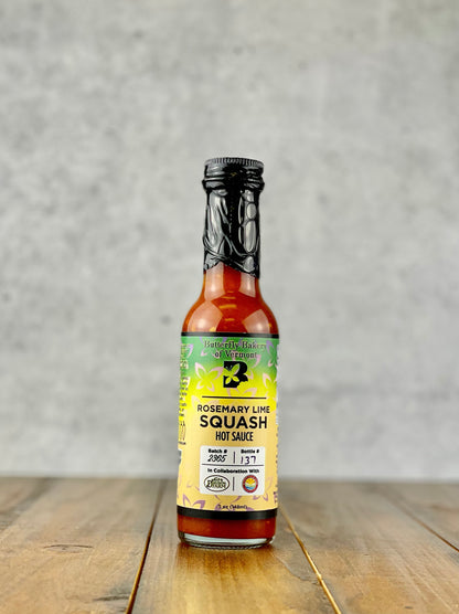 Bottle of Rosemary Lime Squash hot sauce from Butterfly Bakery of Vermont on a wood table