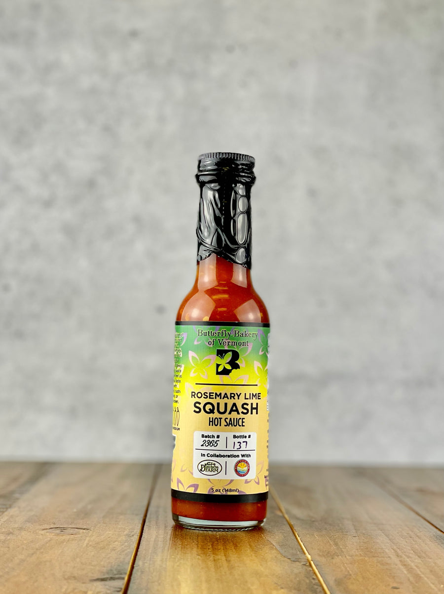 Bottle of Rosemary Lime Squash hot sauce from Butterfly Bakery of Vermont on a wood table