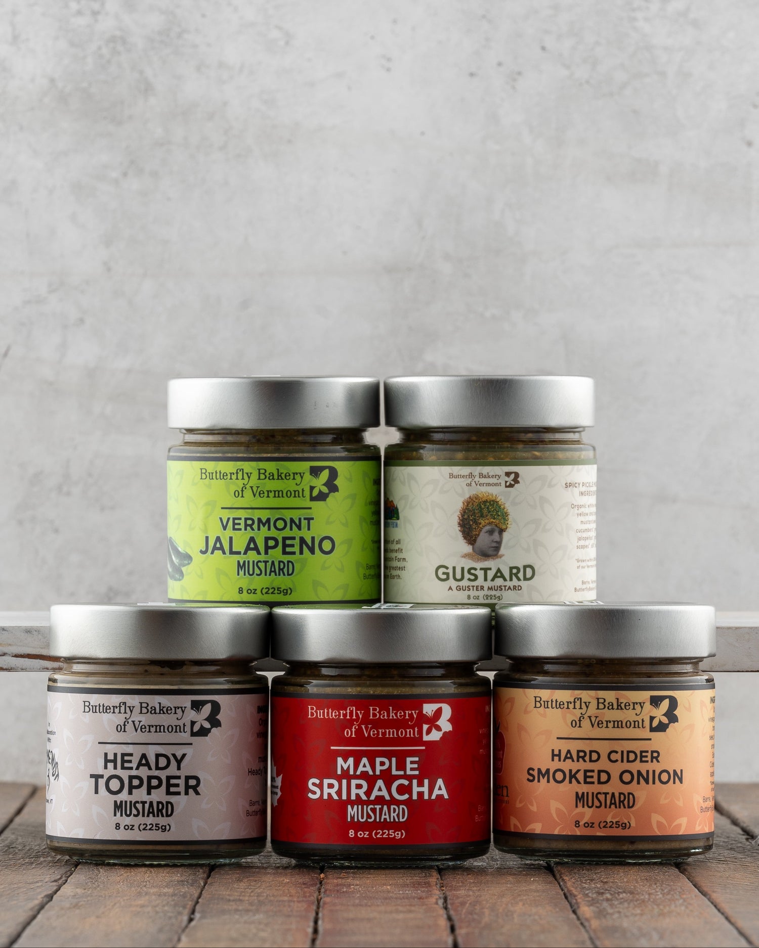 Butterfly Bakery of Vermont full line of mustards on a wood surface 